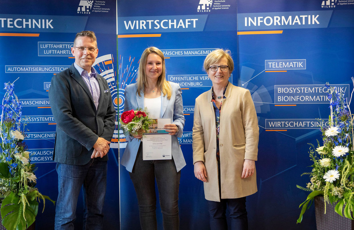 Prof. Dr. Bertil Haack, TH Wildau, Ulrike Vogt, Studentin und Gewinnerin des Förderstipendiums 2019, sowie Prof. Dr. Ulrike Tippe, Präsidentin TH Wildau (v.l.n.r.) Stipendiumvergabe der PROMOS consult auf dem HIT 2019 der TH Wildau